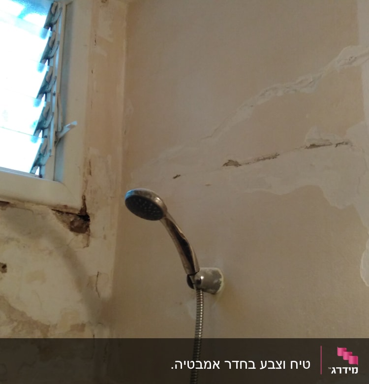 קיר עם סדקים וכתמי צבע מתקלפים